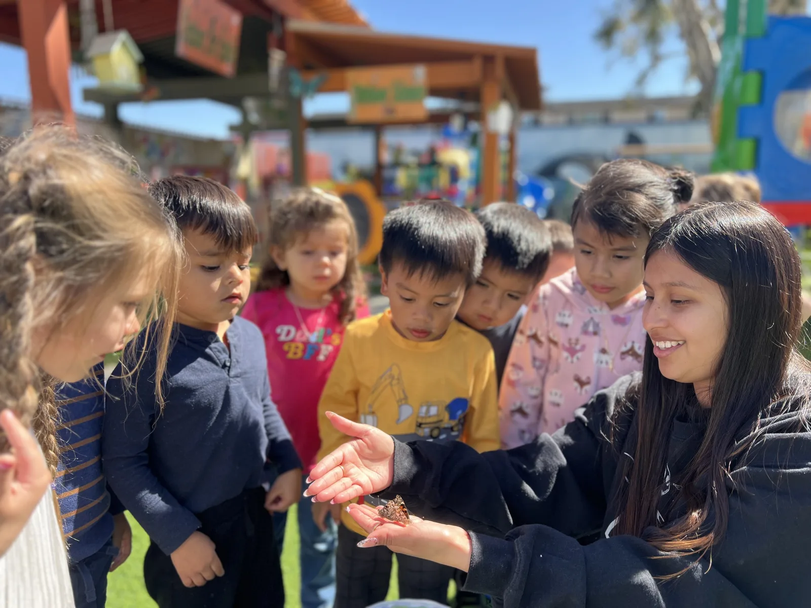 Children enjoying outdoor summer activities, learning, and creative play in a preschool outdoor learning center