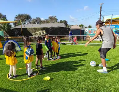 Children practicing soccer skills and teamwork in Kids Adventure Learning Center's soccer enrichment program