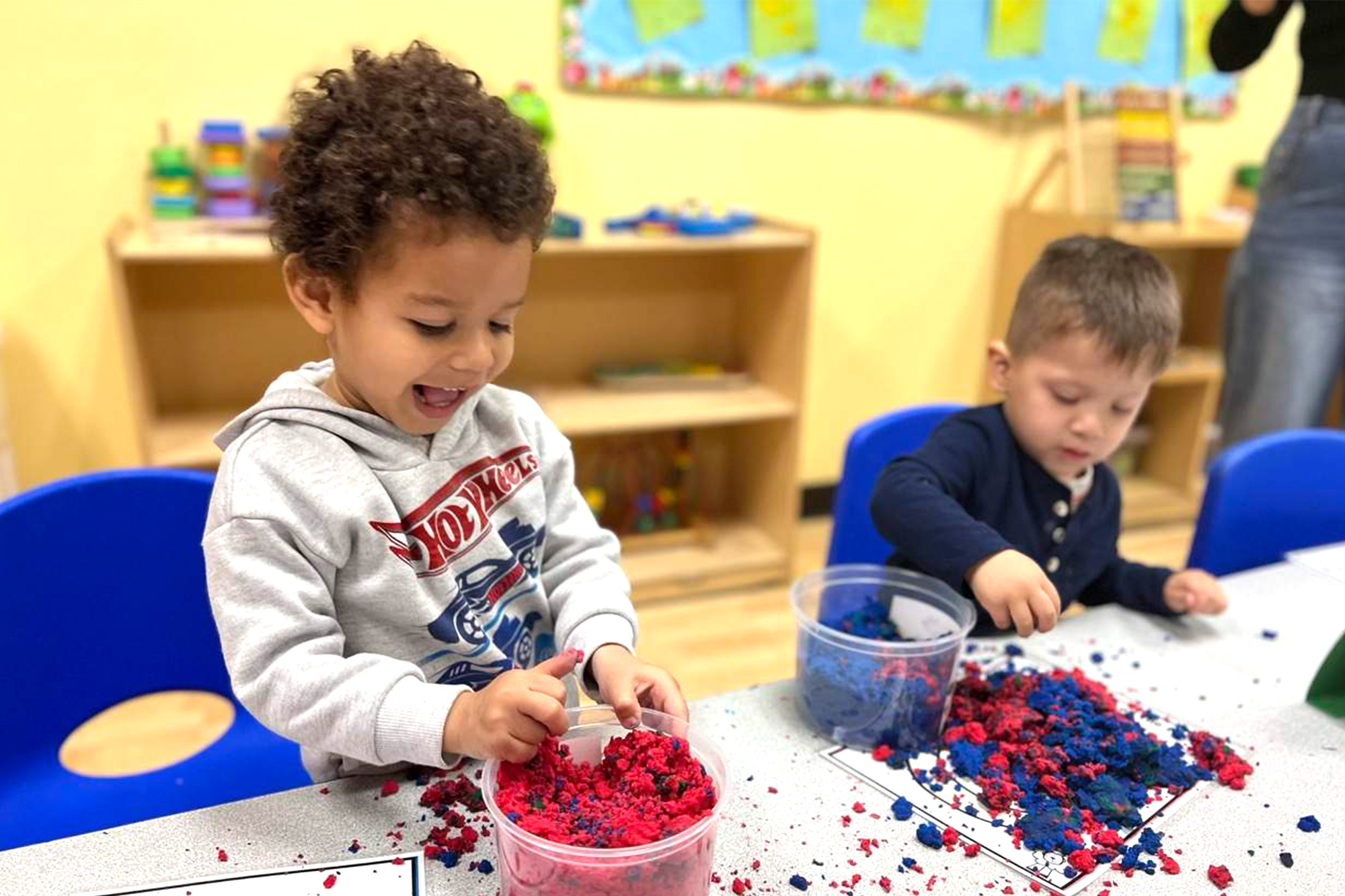 Happy Buena-Park-Toddler playing with colorful educational toys in a bright daycare setting.