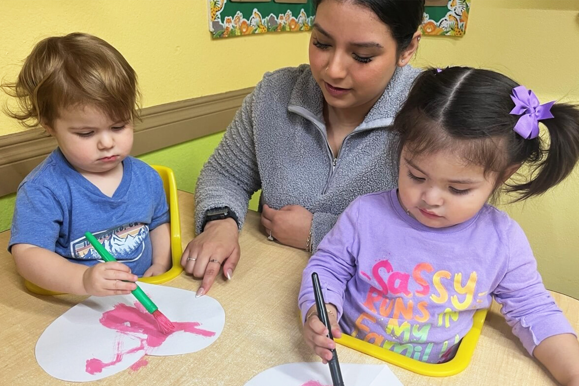 Dedicated staff in Kids Adventure Learning Center helping kids with learning tasks